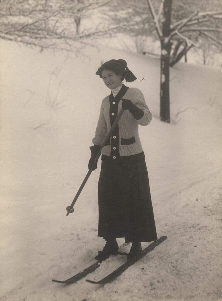 Vintage photo of woman skiing in cardigan sweater. 